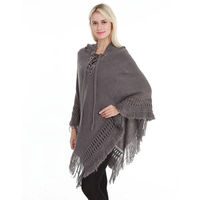 Cape poncho crochet avec capuche franges portée sur pantalon noir urbain