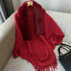 Détail poncho cardigan cachemire tricot épais col fourrure posé sur canapé
