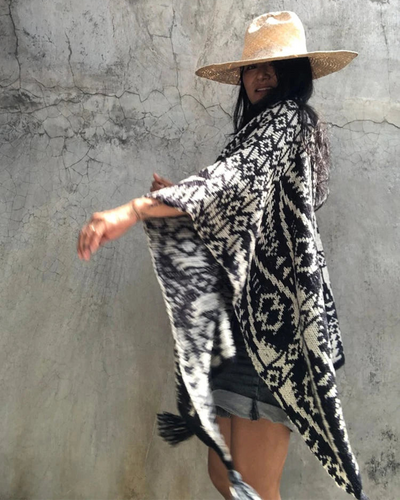 Femme portant poncho motifs géométriques aztèques avec chapeau style bohème