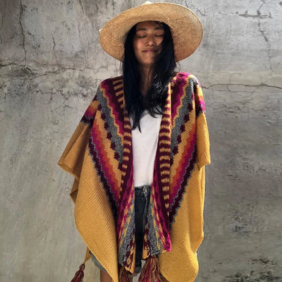 Femme portant poncho du Pérou tricot rayures zigzag franges colorées